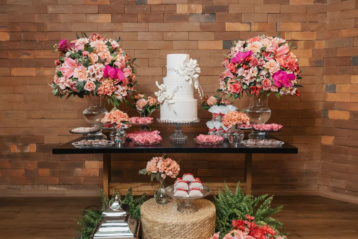 Bolo de casamento de três andares em mesa decorada
